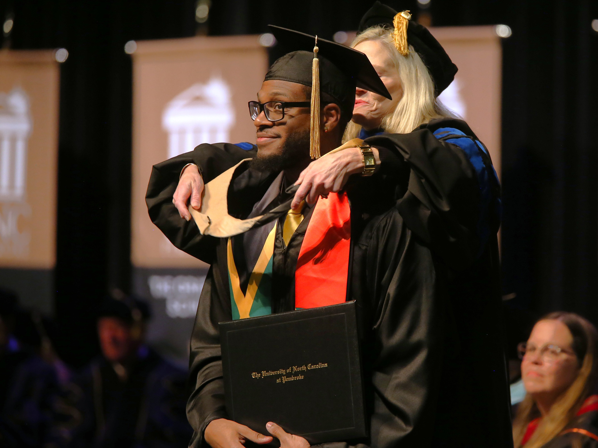 student receives hooding at Grad School commencement UNCP
