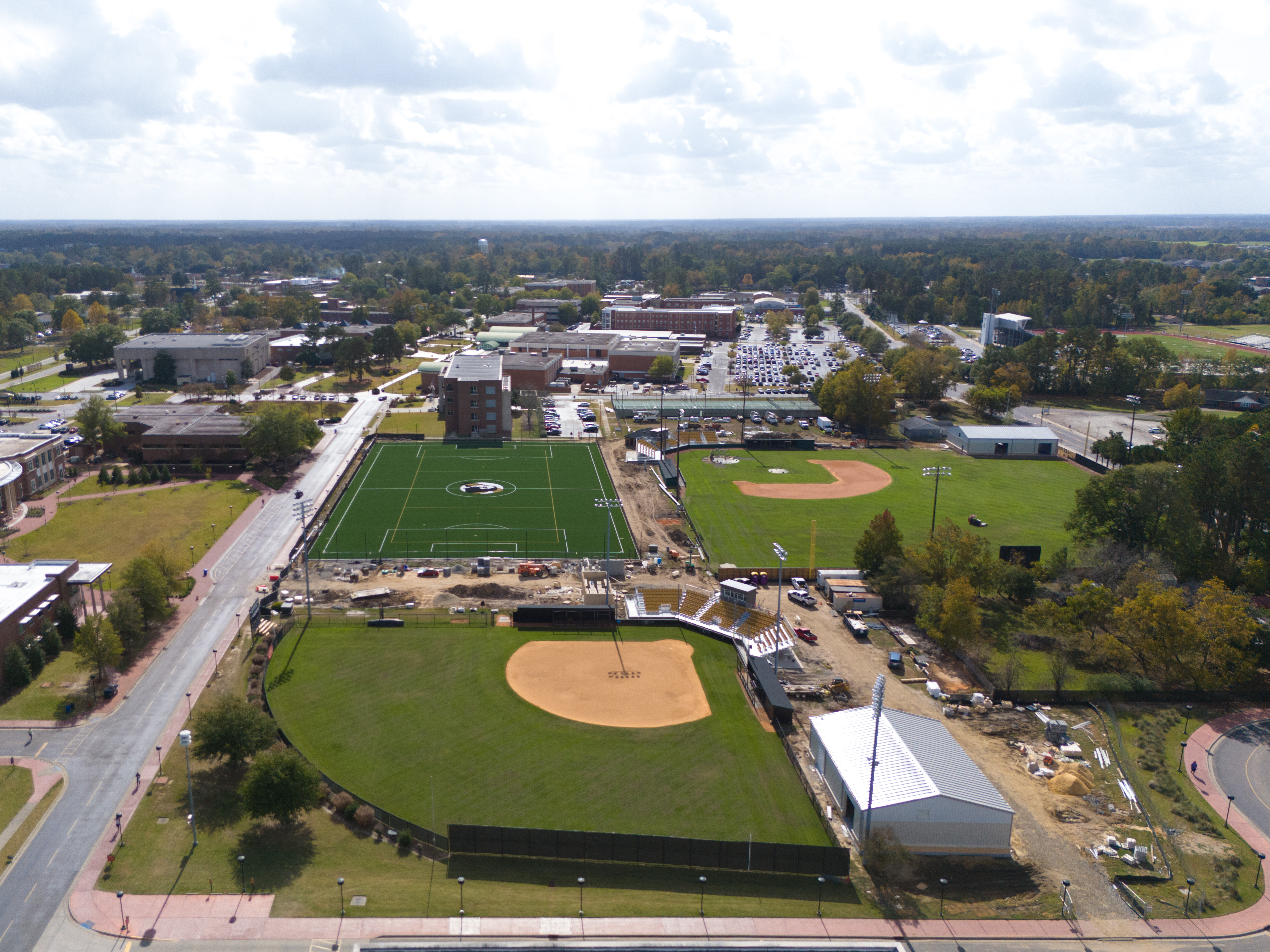 An aerial view of a campus with multiple baseball, softball and intramural field. Surrounding these fields are various buildings, parking lots, and roads.