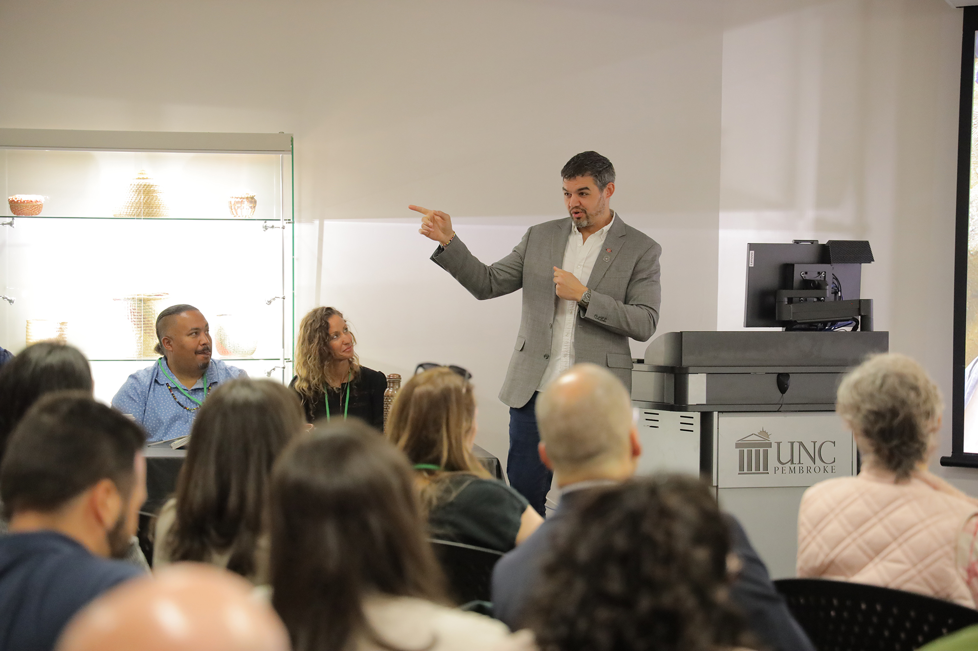 a guy sitting at a desk with forensics in his hand