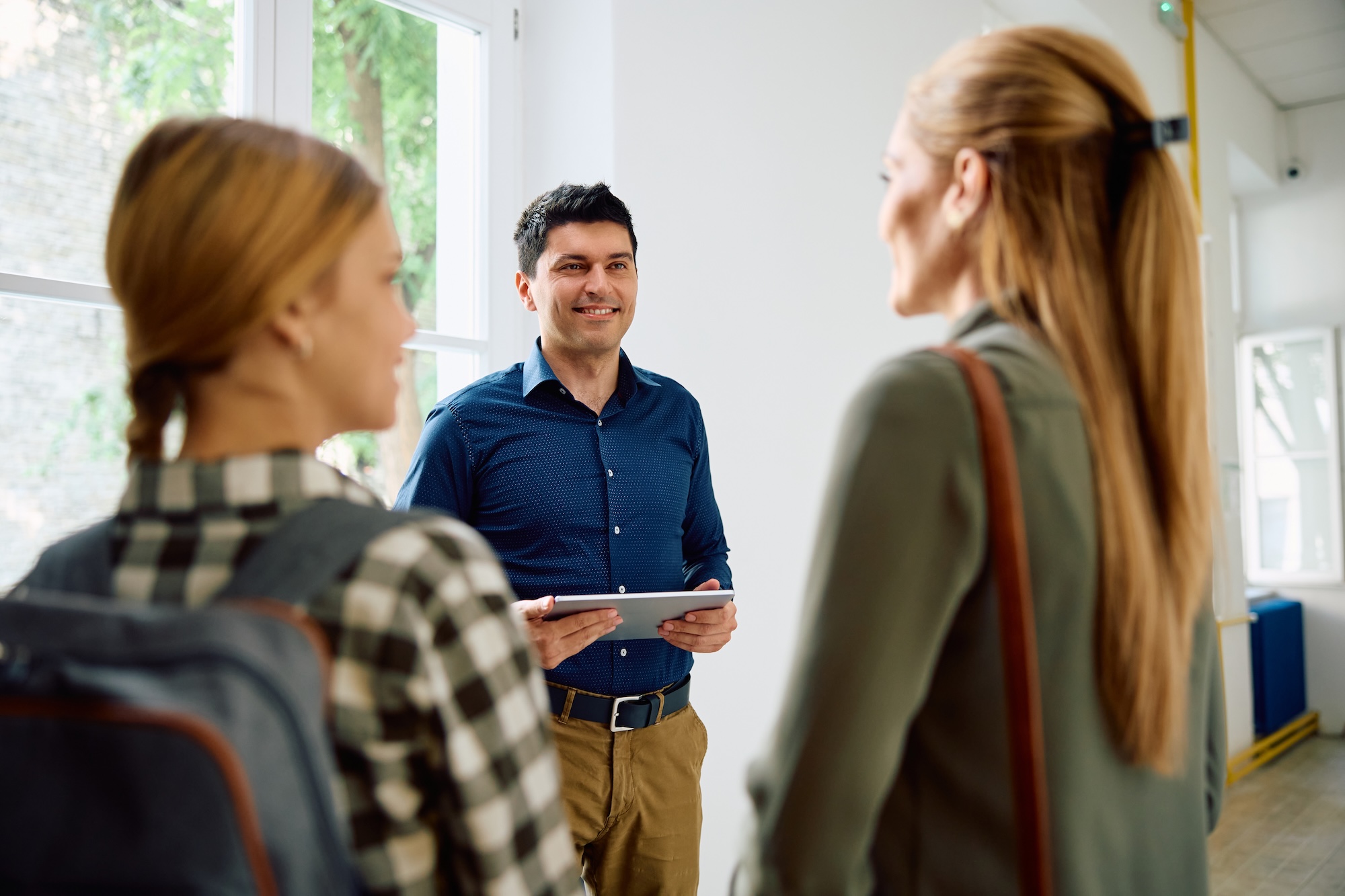 male administrator talking to a parent and kid