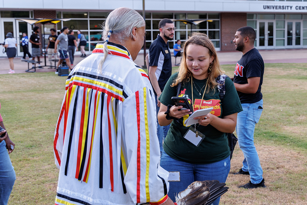 student reporter interviewing a man at UNCP