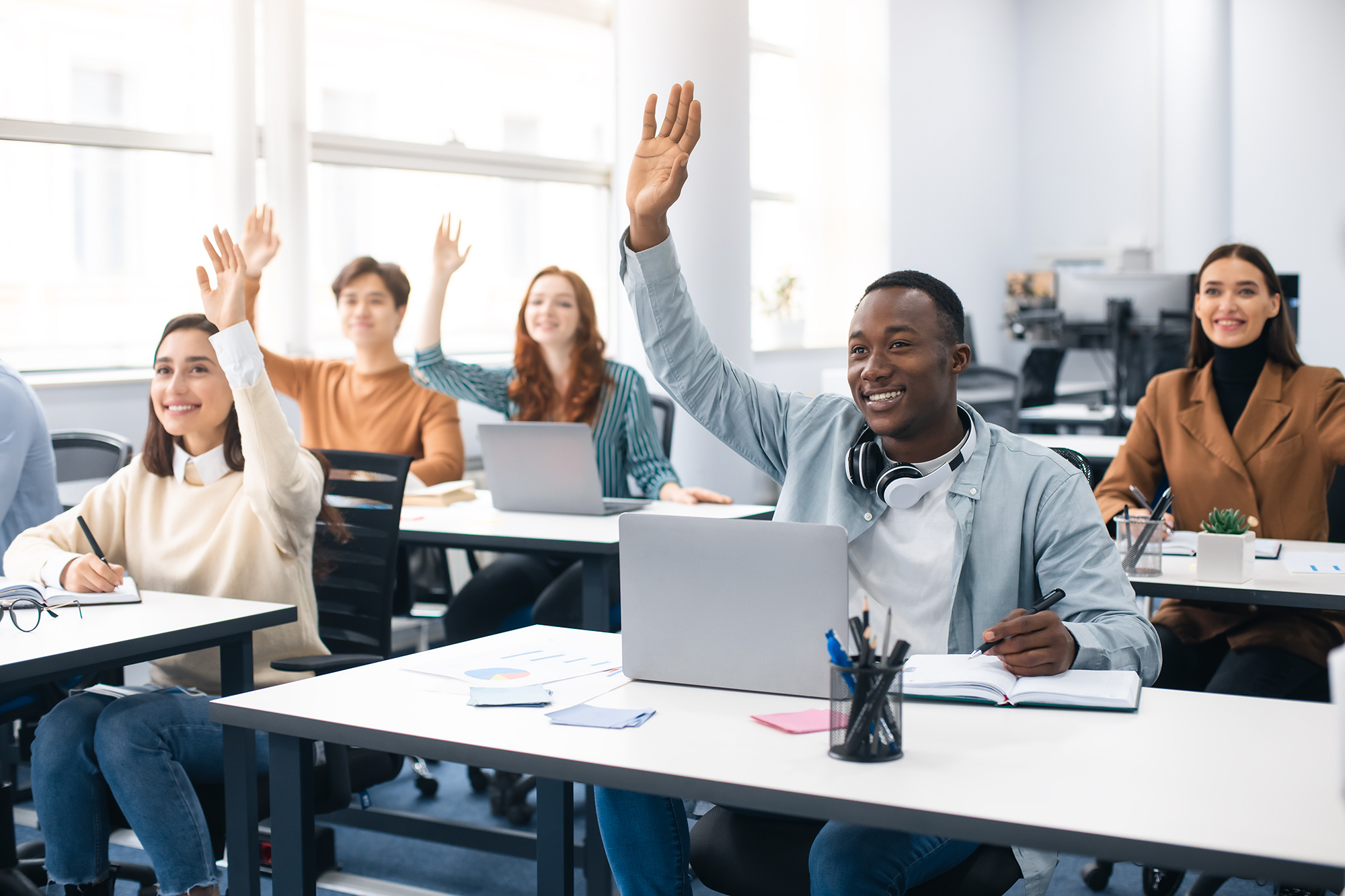 class with students raising their hands