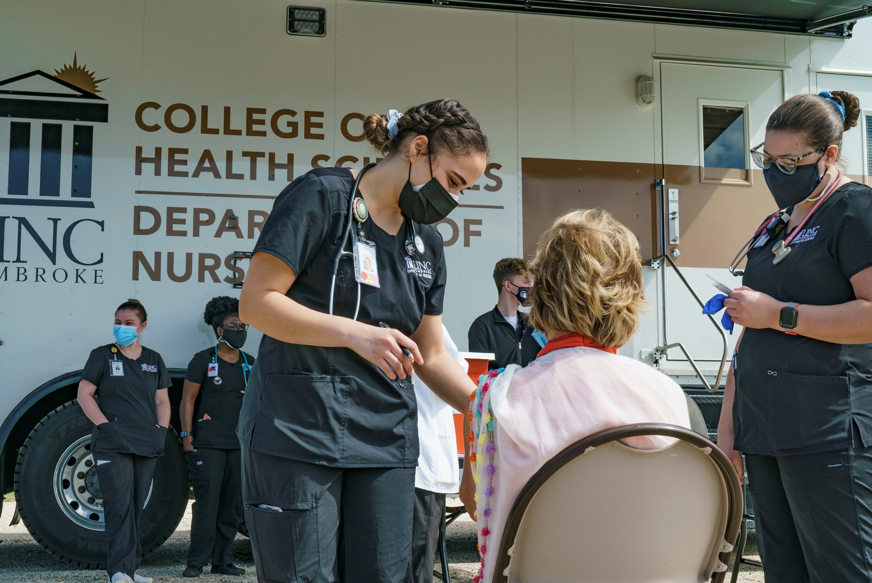 UNC Pembroke nursing students and faculty working out of a mobile unit to provide COVID vaccinations to teachers and staff at a local school.