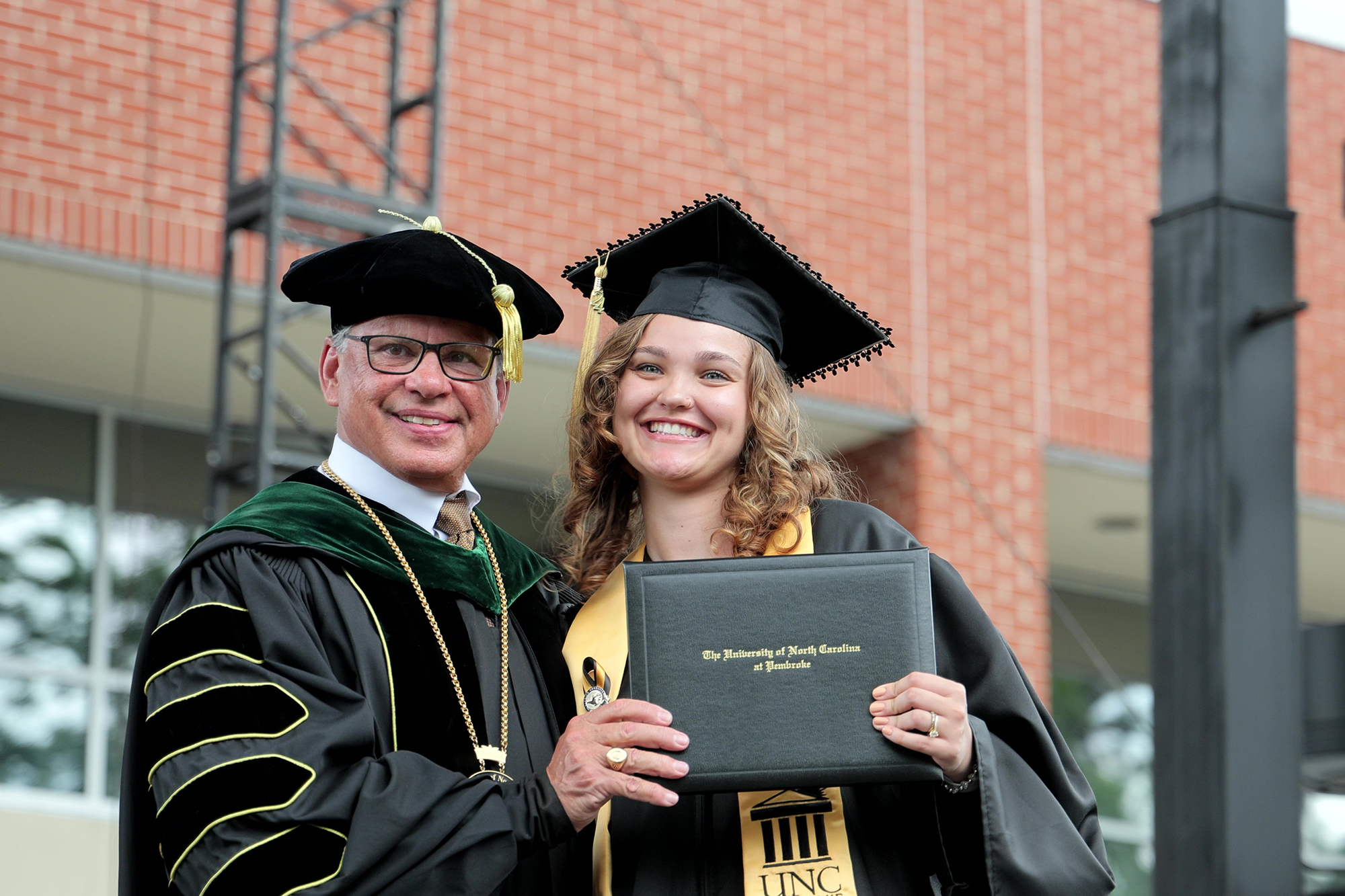 female UNCP graduate with diploma