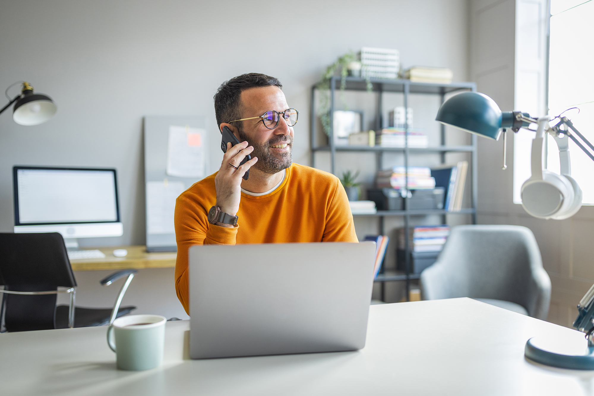 man on phone in front of laptop