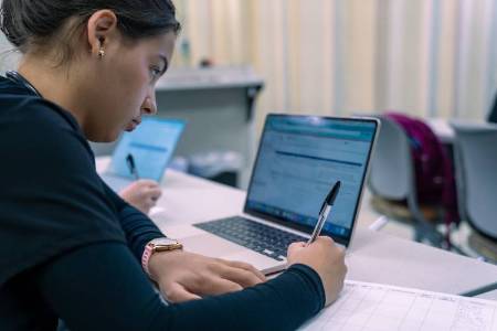 UNCP nursing student on a computer in classroom