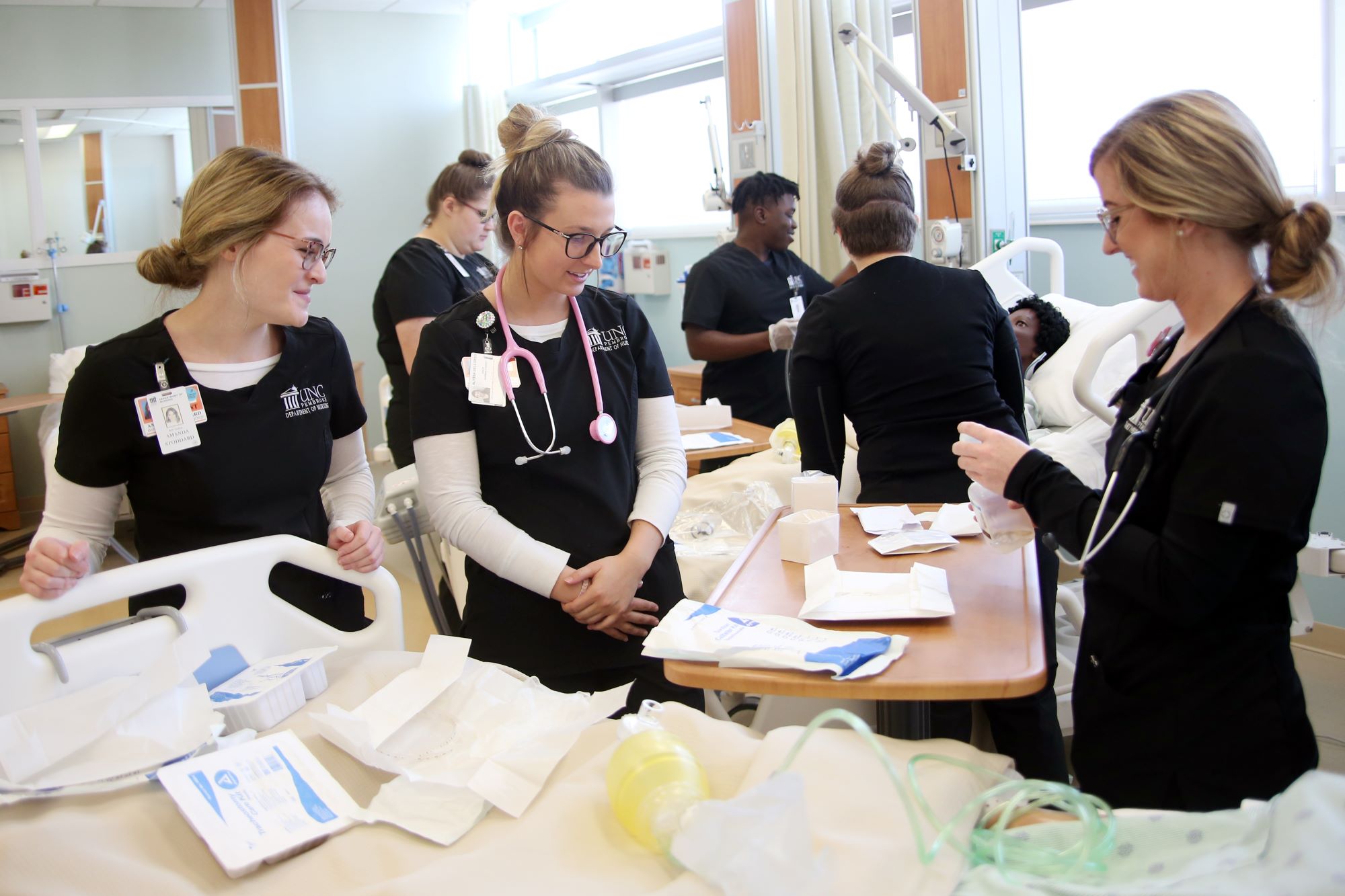 UNCP student in scrubs doing a simulation