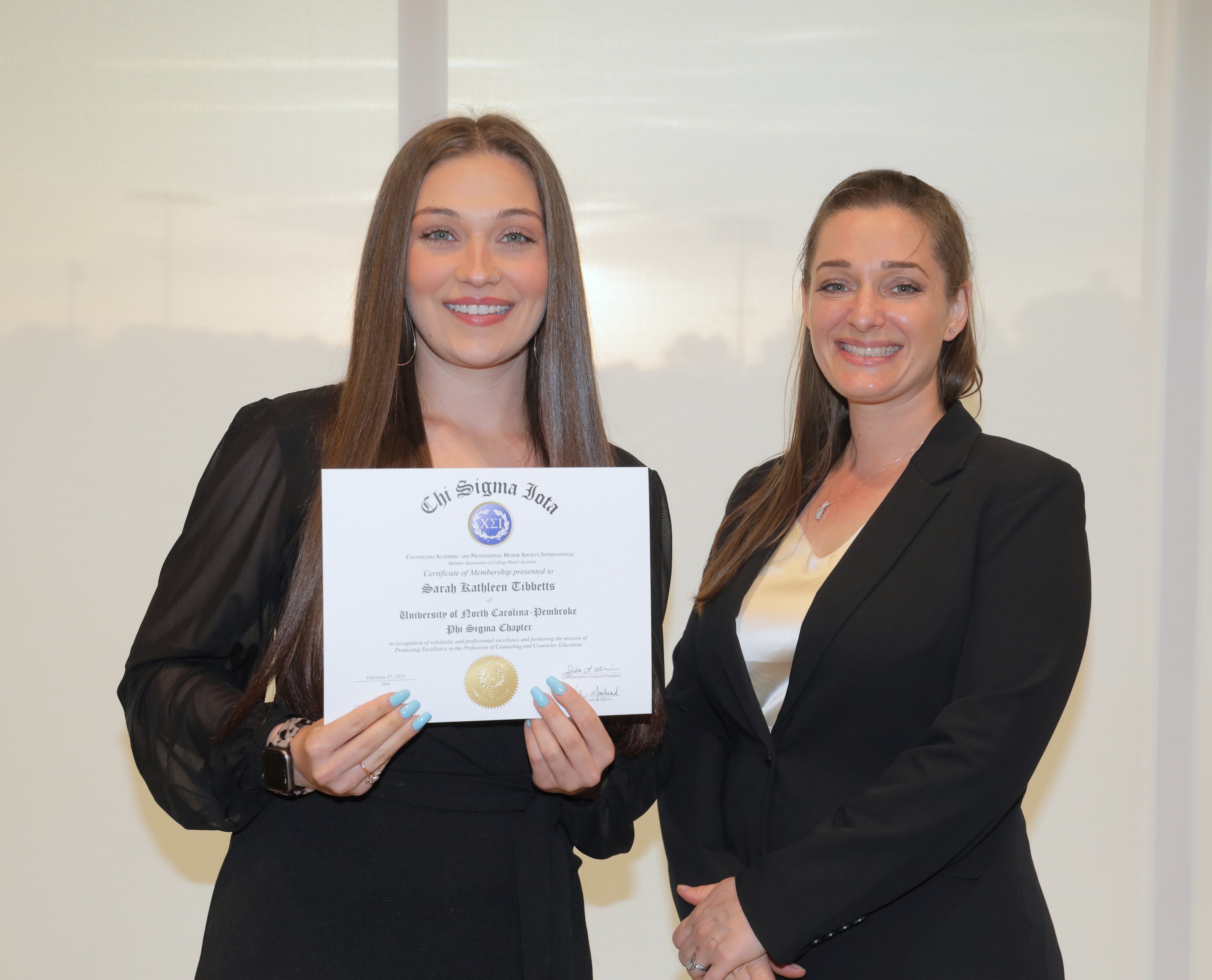 Student Sarah Tibbet (left) recieves her certificate of induction to Chi Sigma Beta from Nicole Stargell, chair of the Department of Counseling (right).