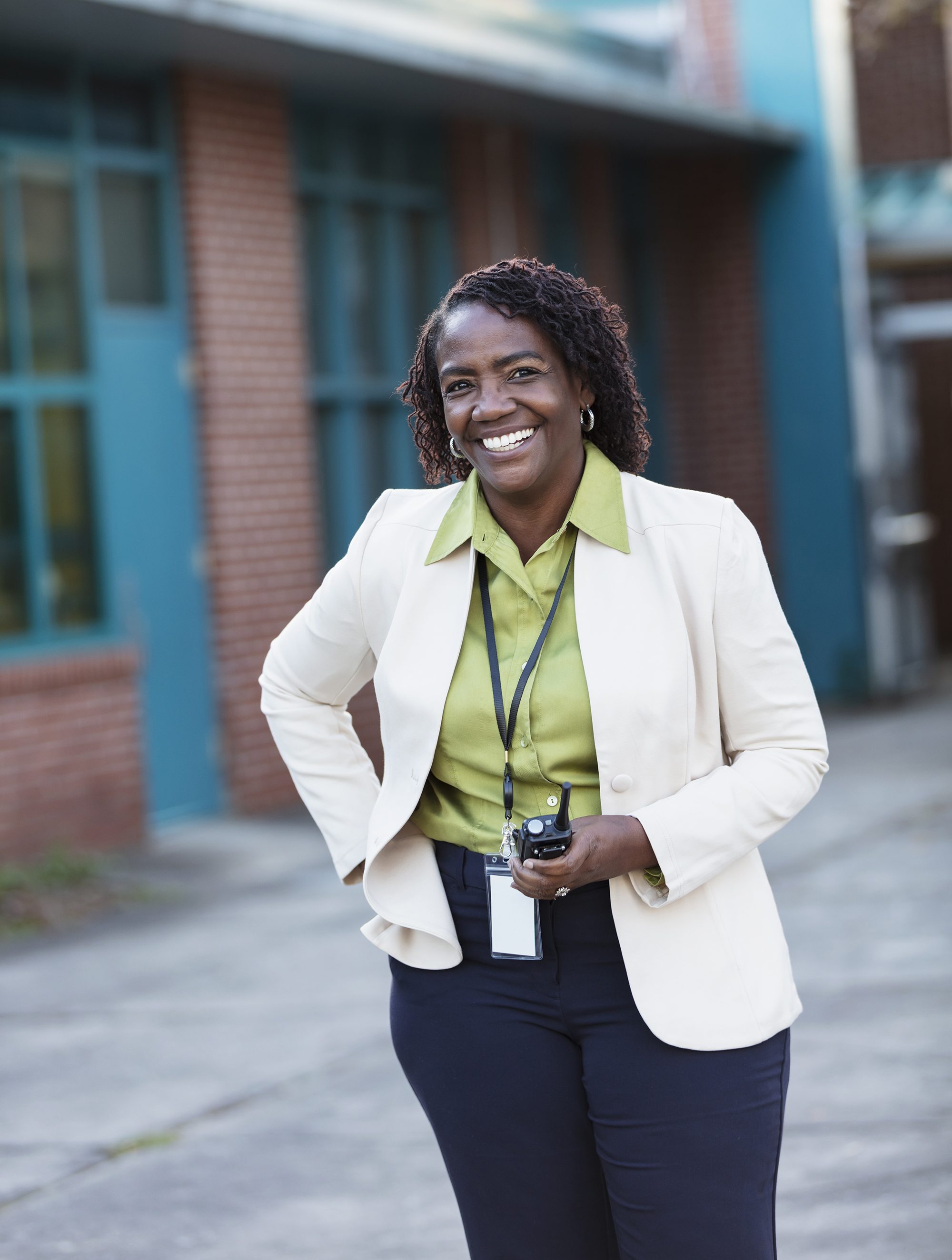 African American woman in dress clothes in front of a school building