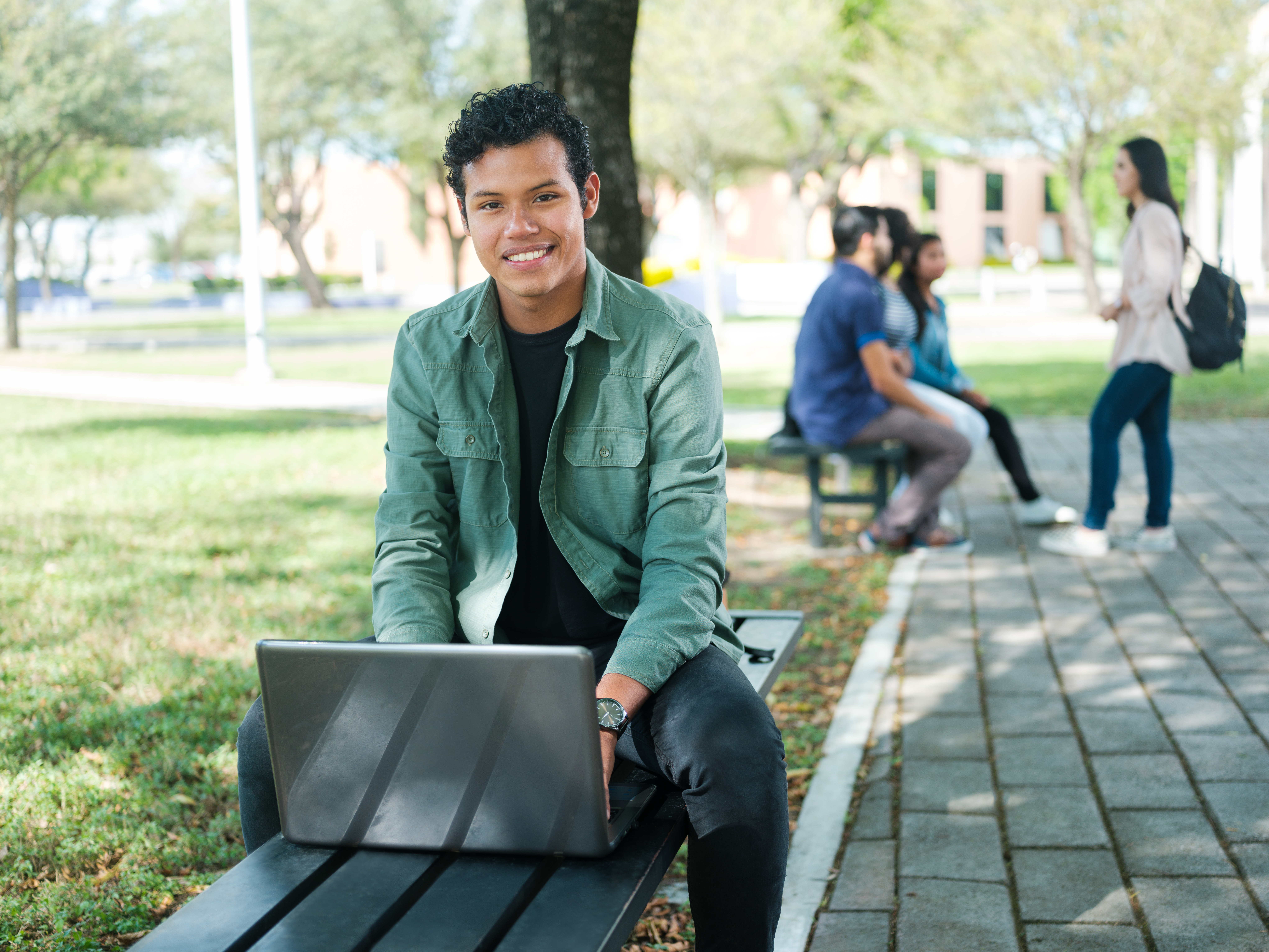 student on laptop and bench