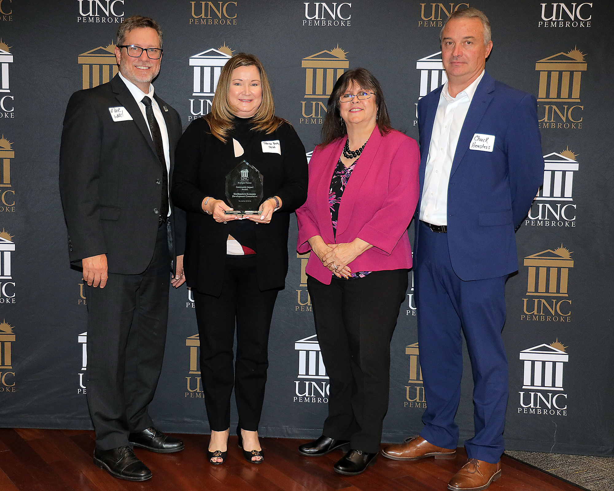 Business Visions award winners in front of a UNCP backdrop