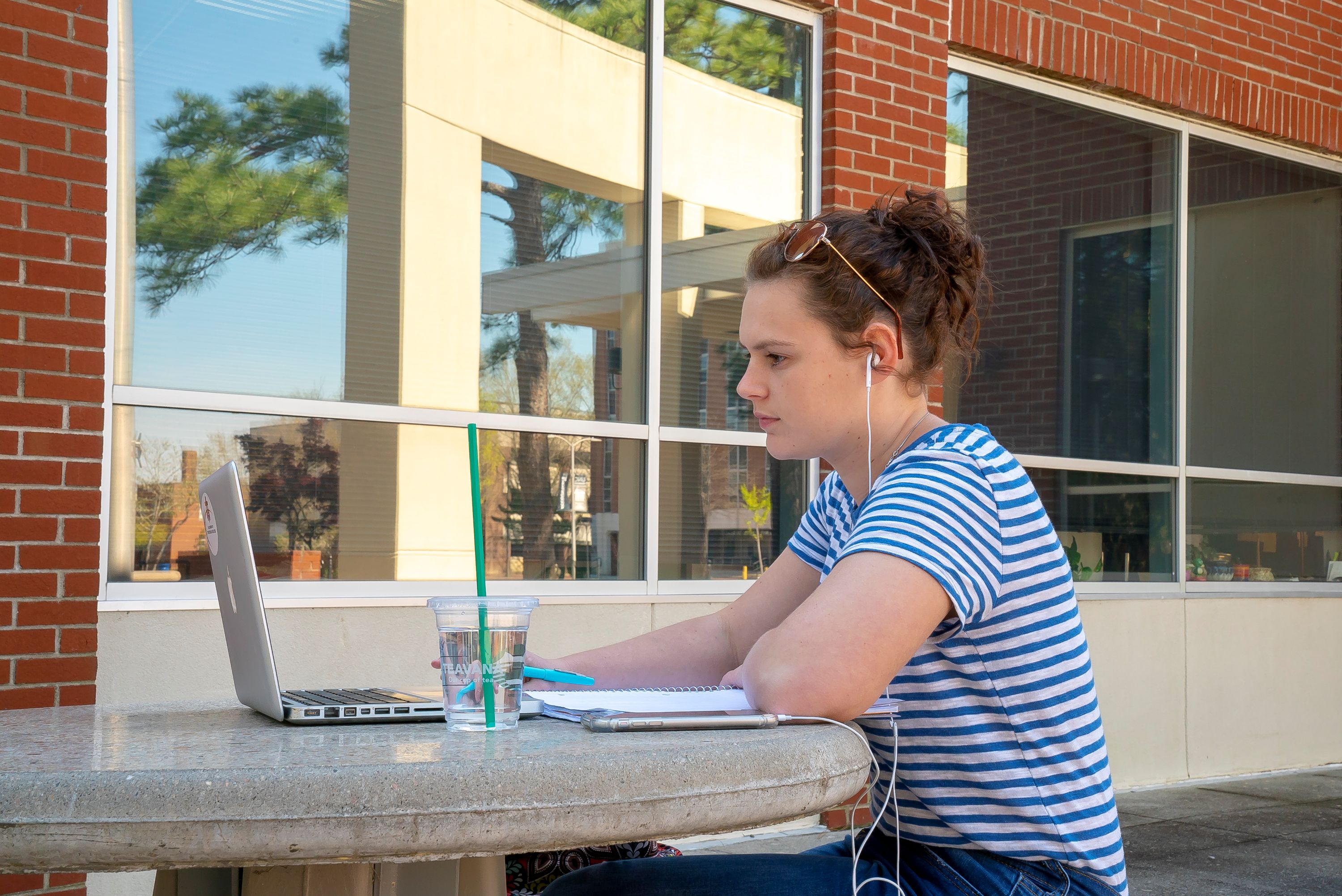 student on laptop outside at UNCP