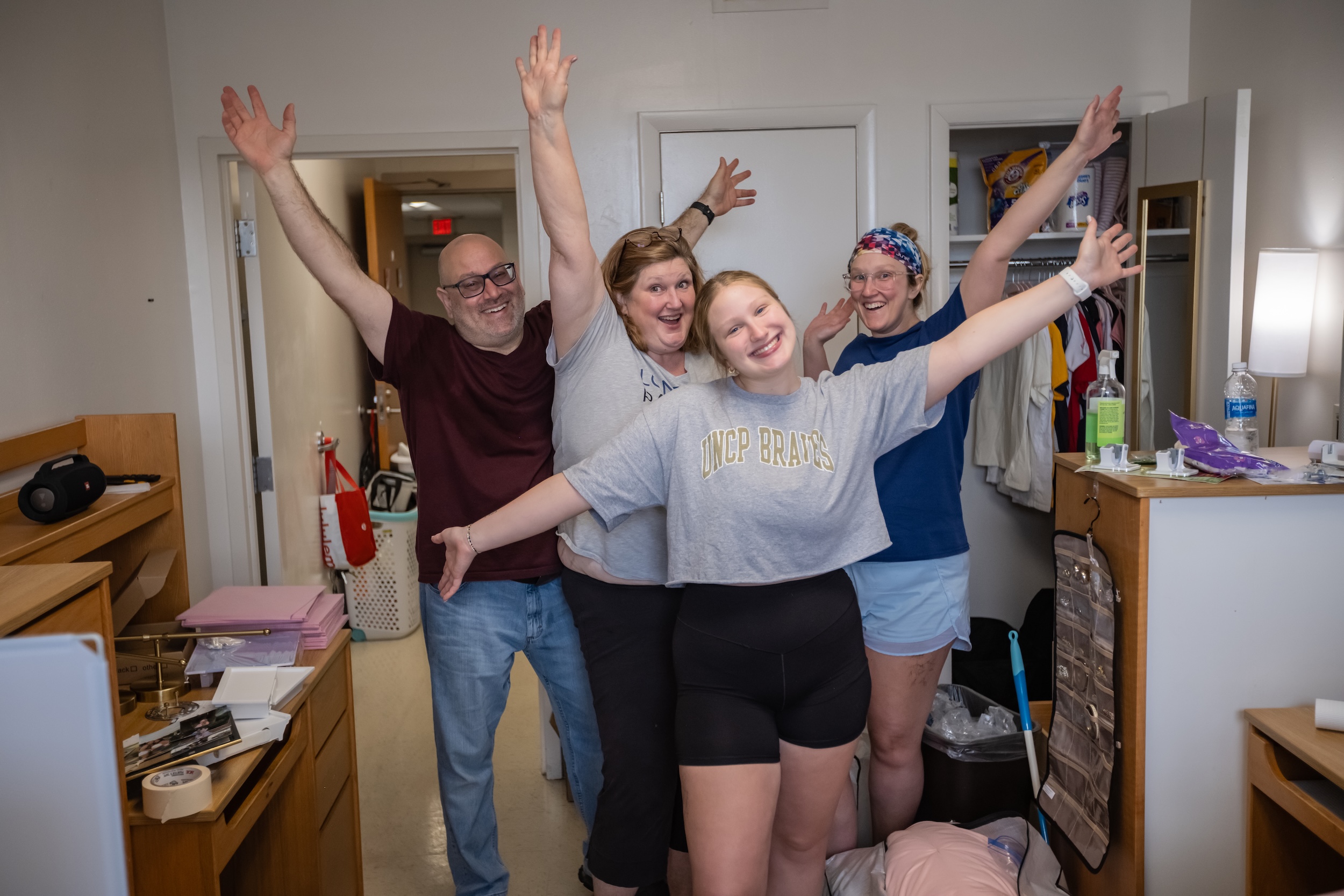 UNCP student with family arms up moving into dorm