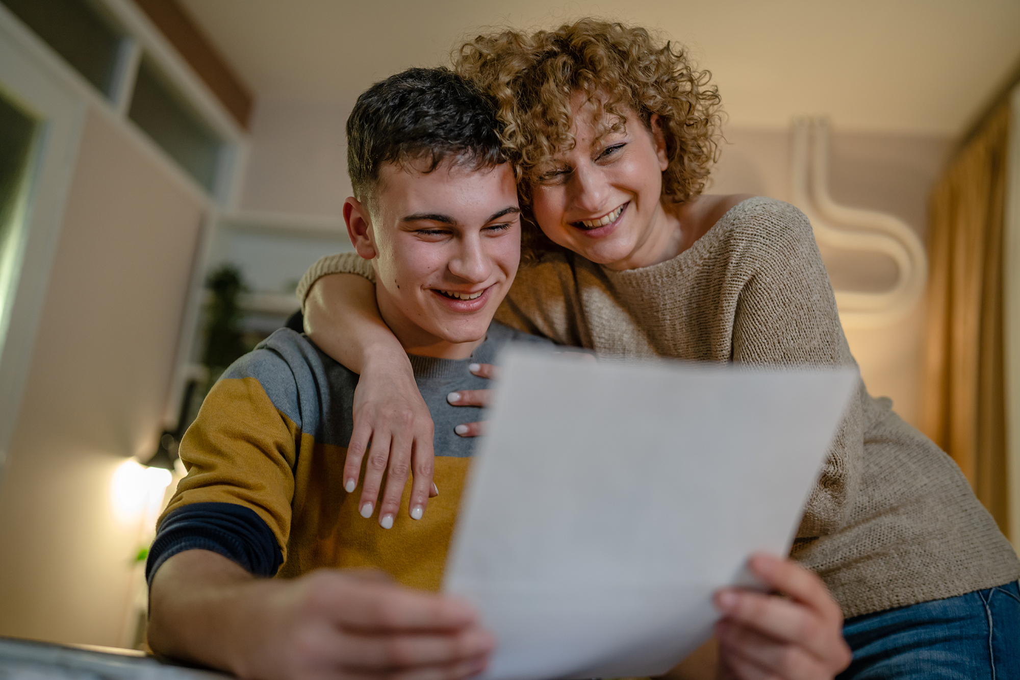 Mother and son looking at college paperwork and smiling