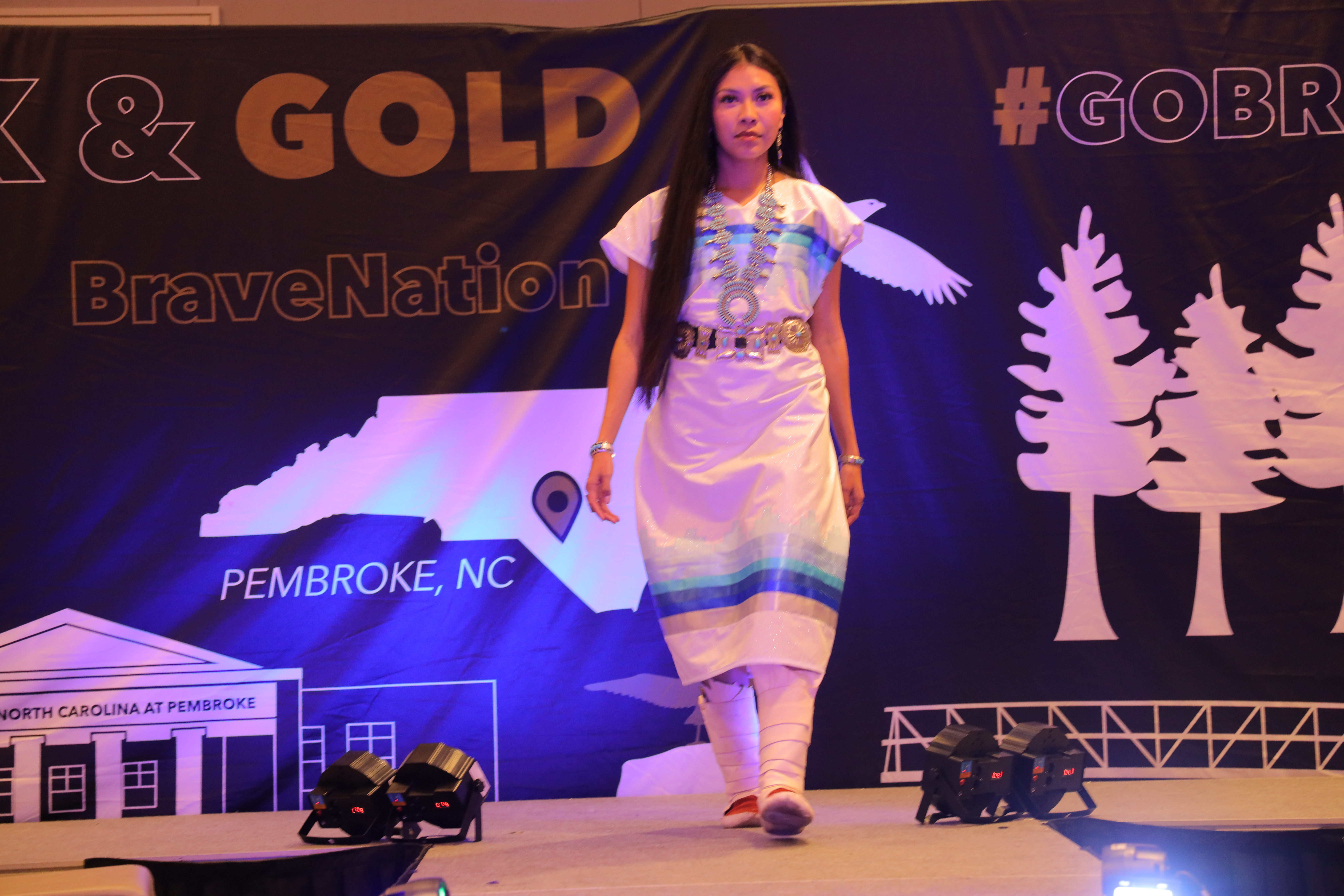 female on the runway at a Ribbon skirt fashion show