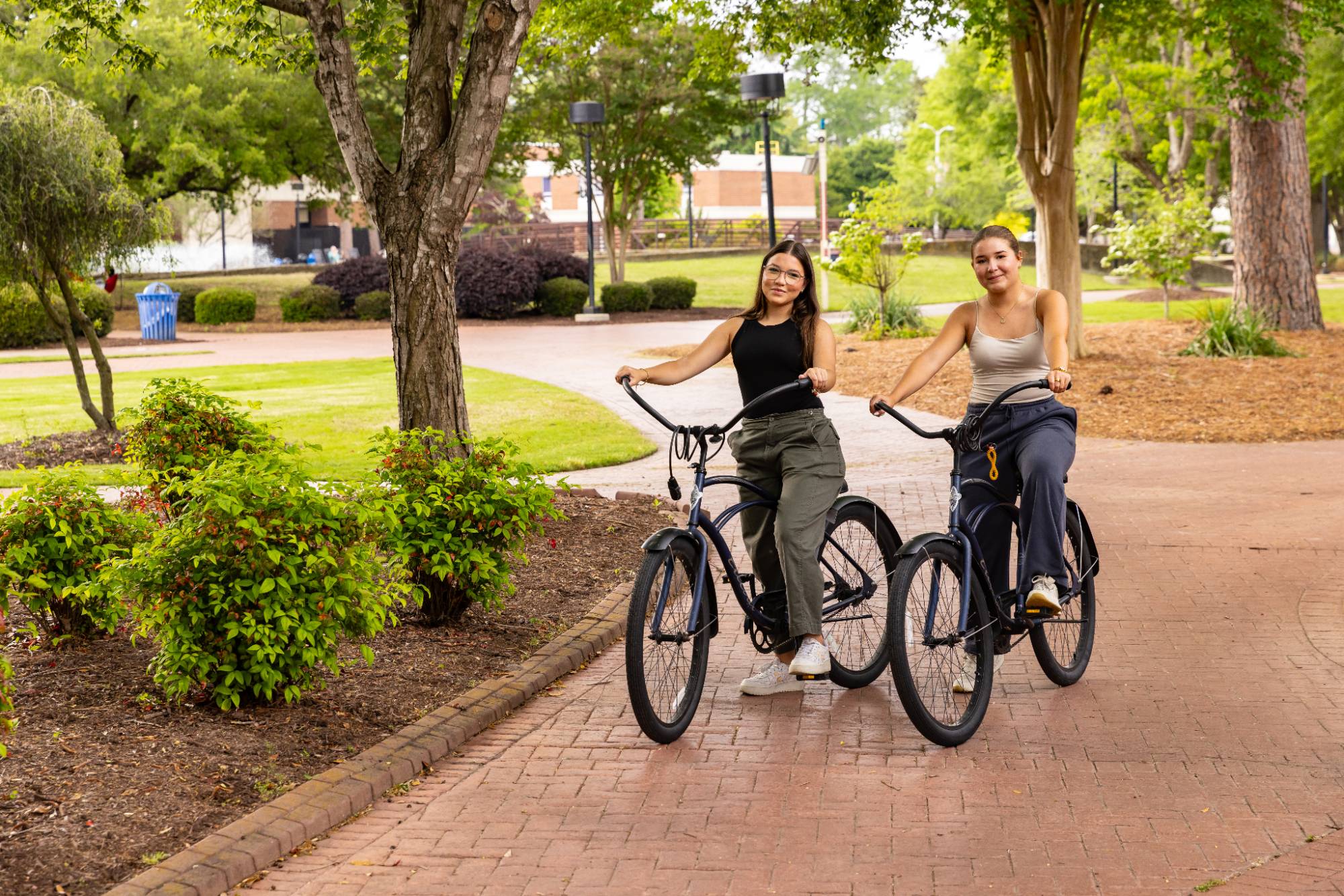 Two UNCP students riding bikes on campus