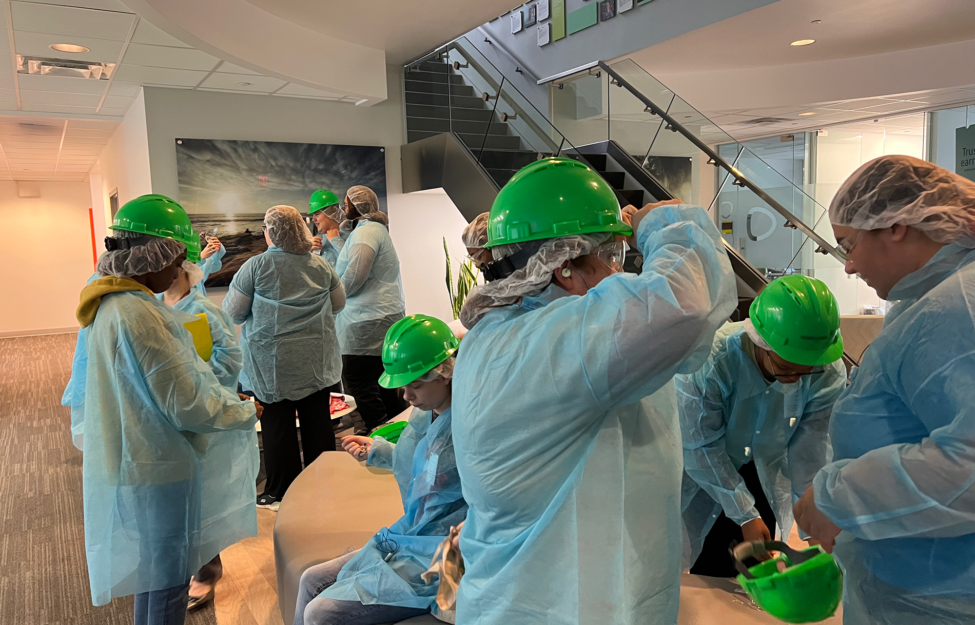 group of students donning hazmat suits in a building lobby at UNCP