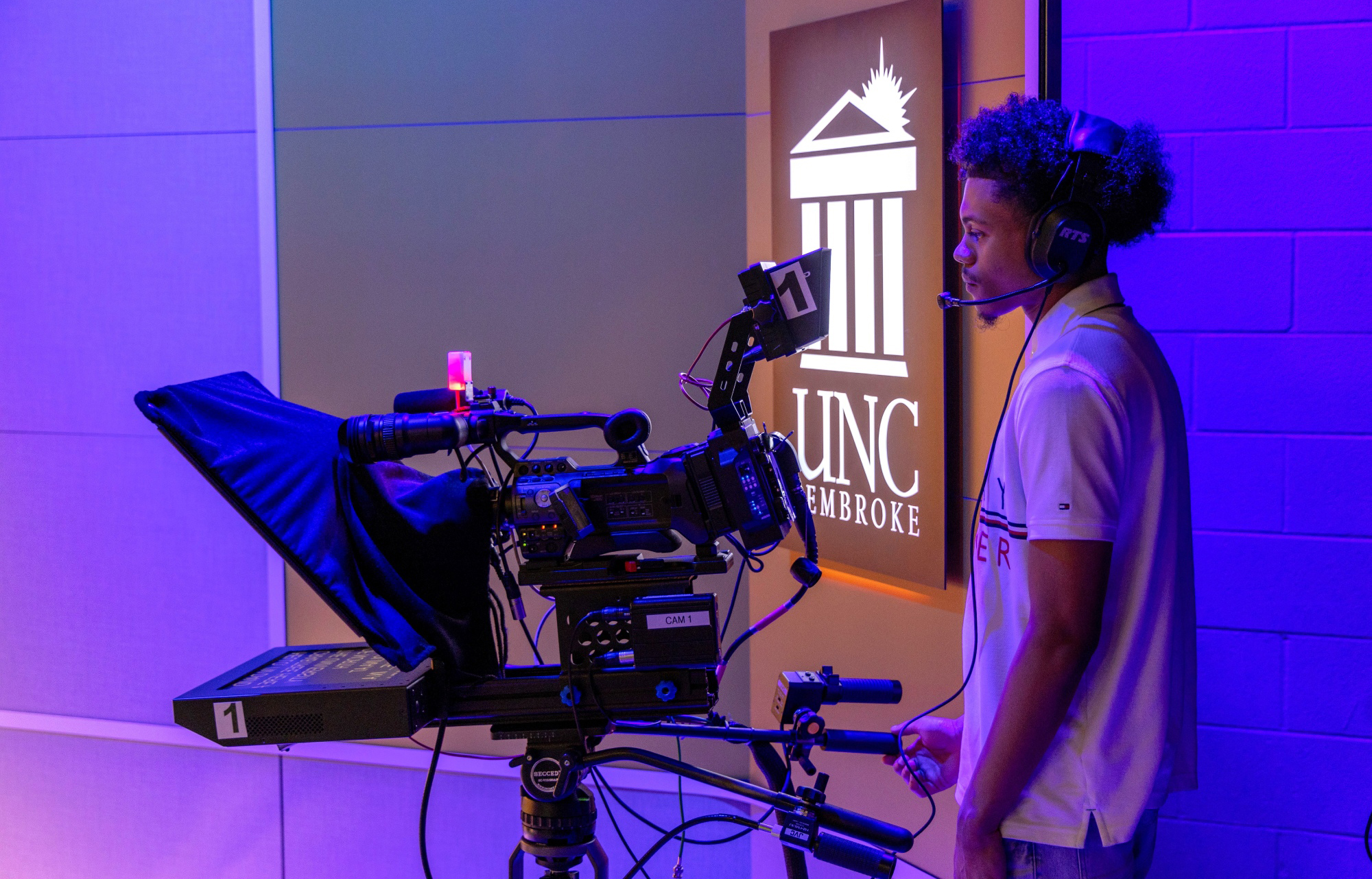 UNC Pembroke Mass Communication student working a broadcasting studio camera in the UNCP TV station.