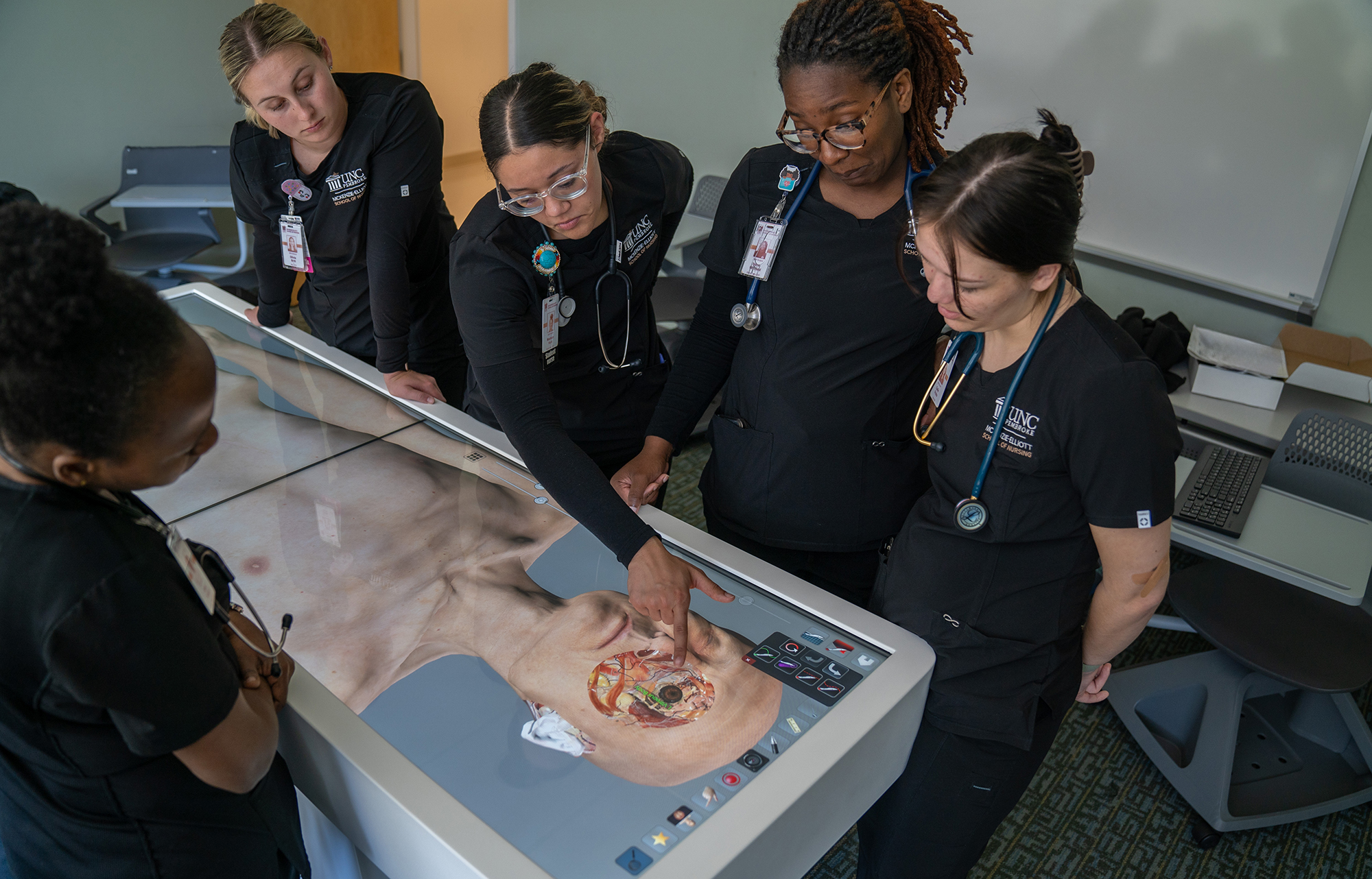 A group of student nurses use the anatomage table in the UNCP Nursing lab