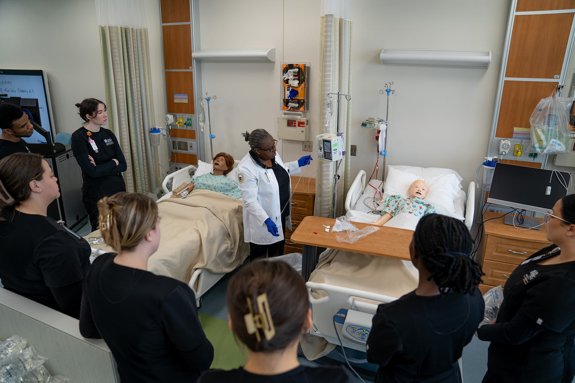 students work with a faculty member in the sim center of the McKenzie Elliott School of Nursing at UNC Pembroke.