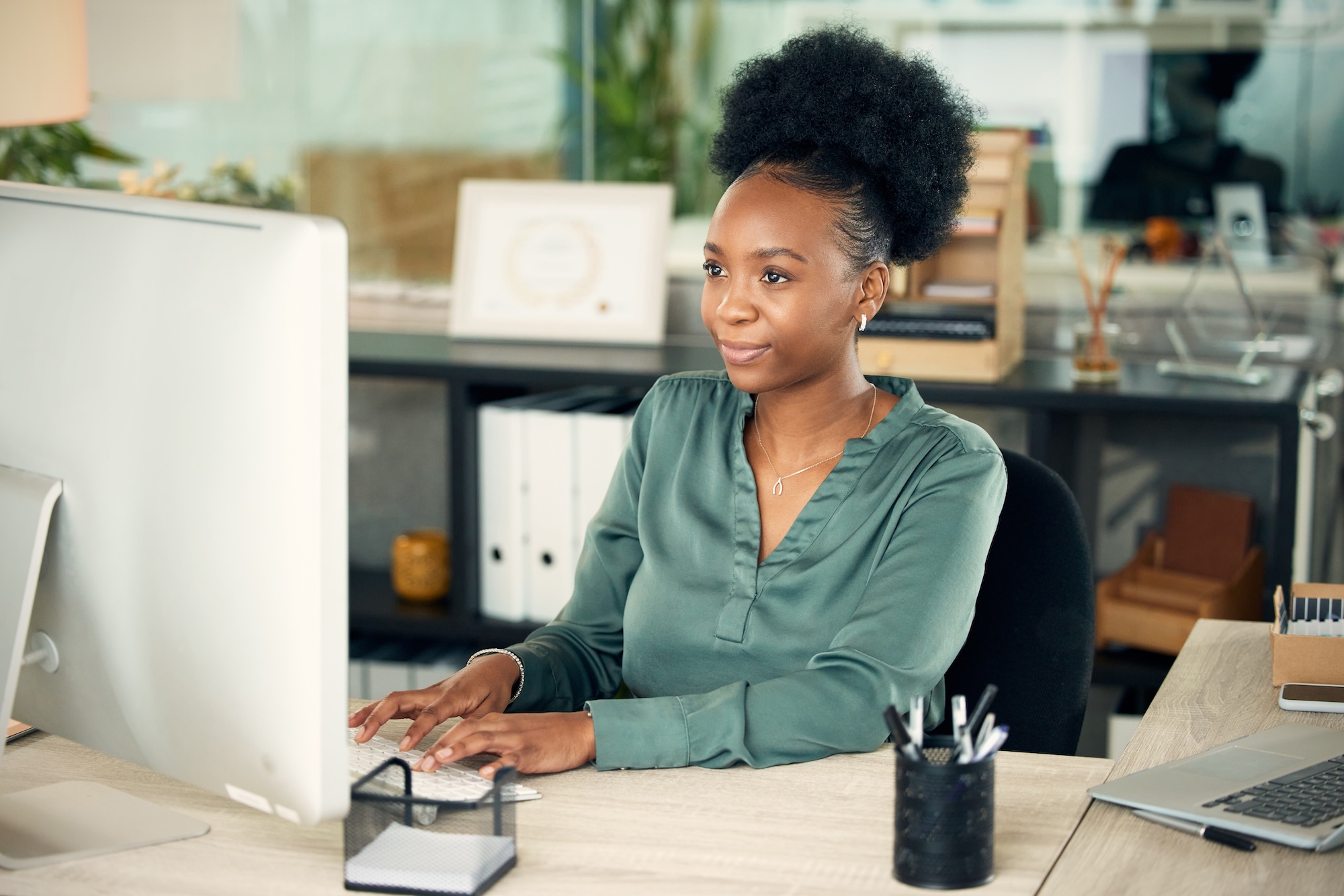 Woman sitting at desk looking at computer