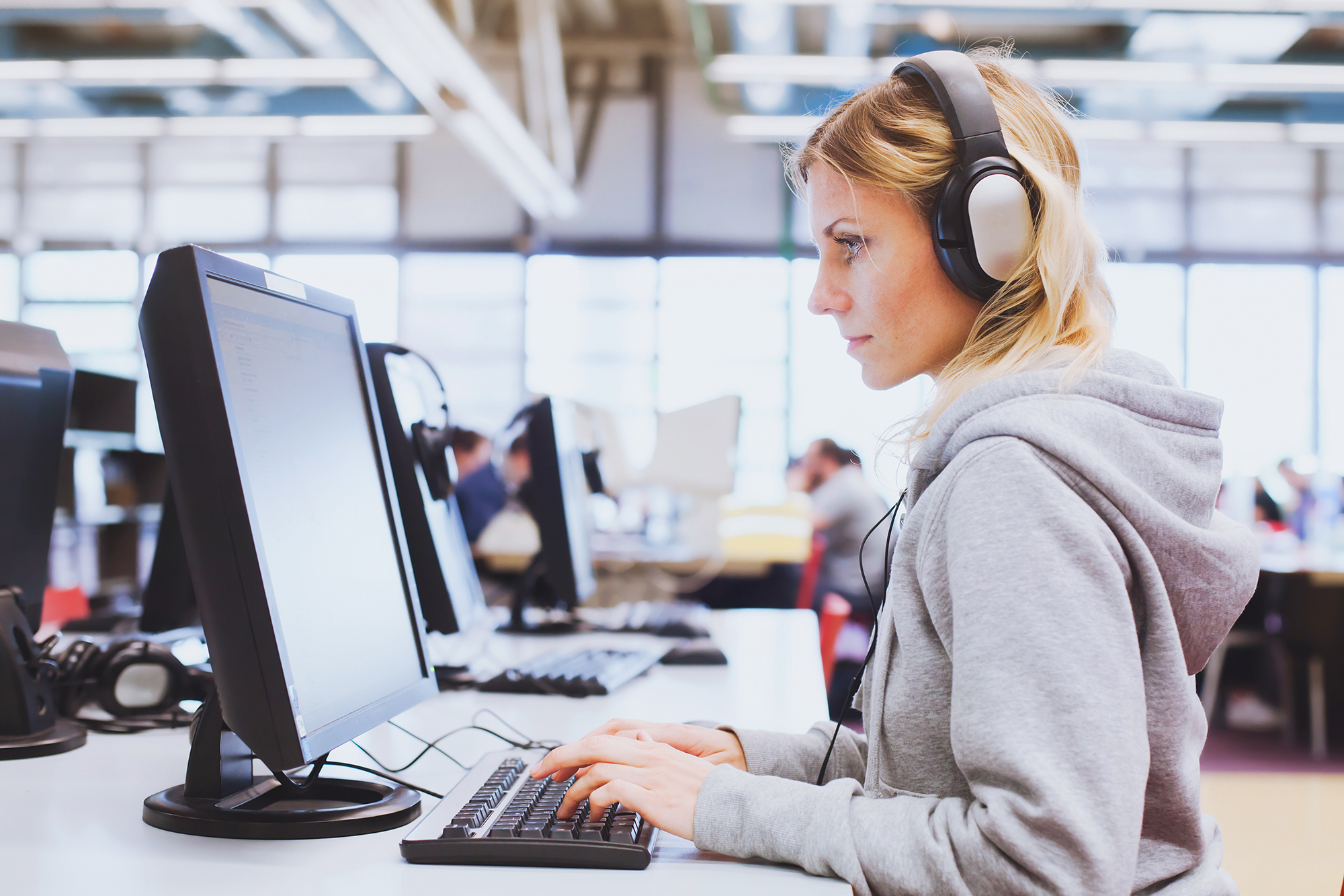 woman wearing headphones at a computer taking a test