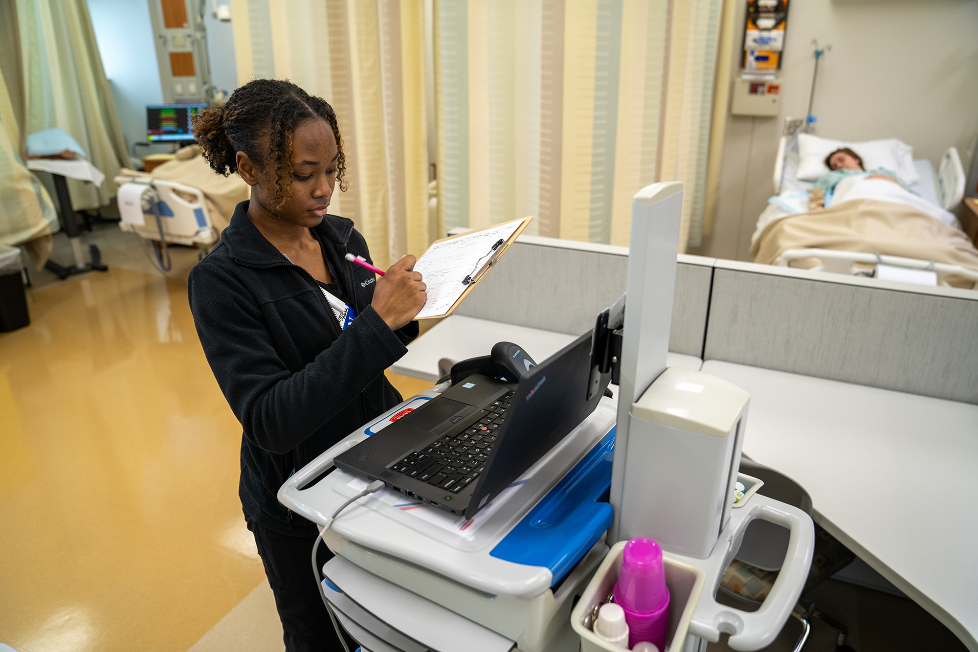 female BSN student with clipboard taking patient notes at UNC Pembroke