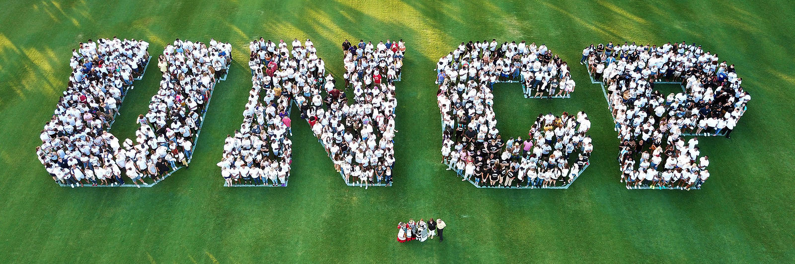 UNCP Logo with Students on Field