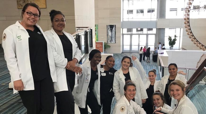 Nursing students posing on a stairwell. 