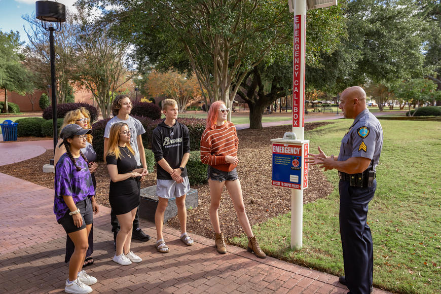 Officer Brooks explaining the Call Box to a group of students.