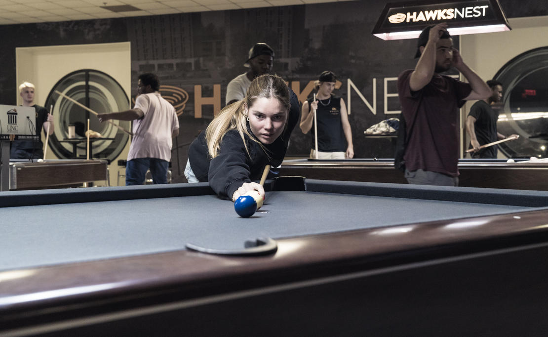 Students playing pool and ping pong in the Hawks Nest.