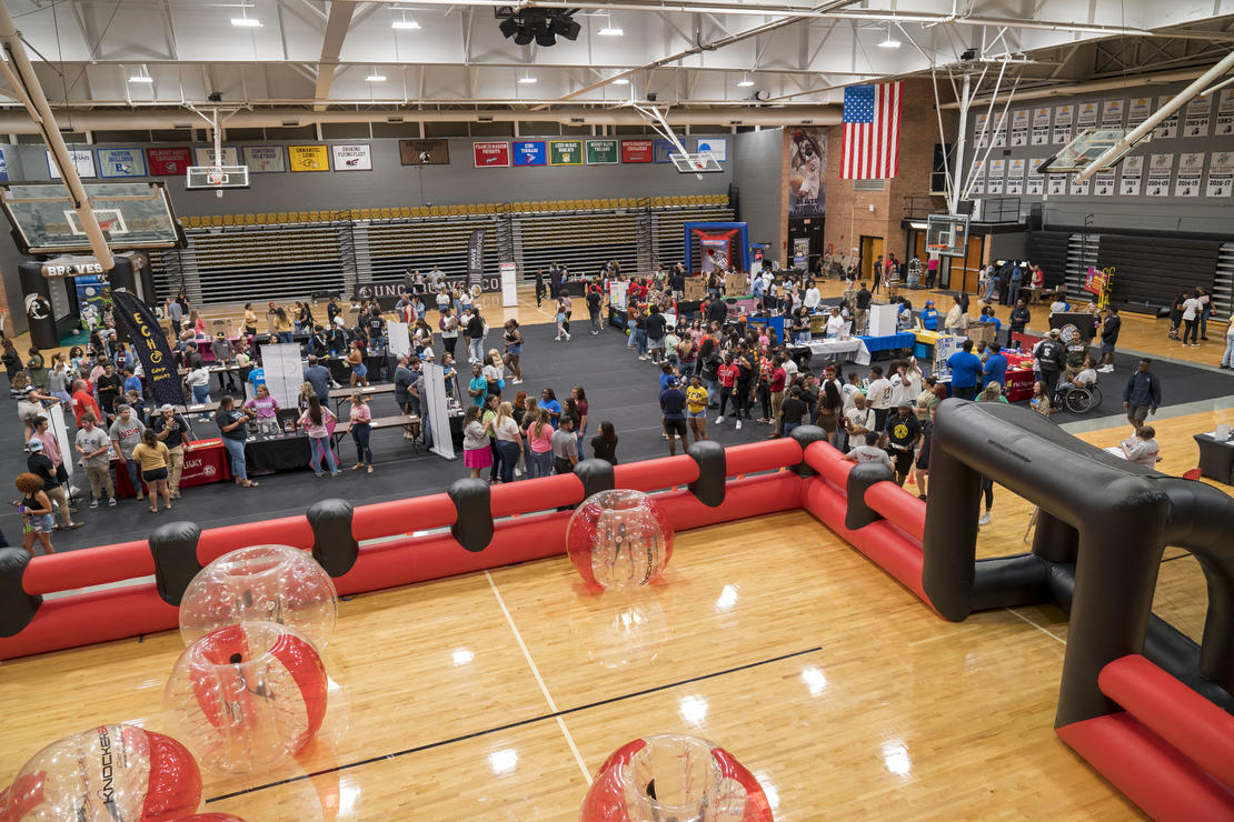 An overview shot of BraveNation Bash with students playing Bubble Soccer, talking with other students, and playing other games with vendors. 