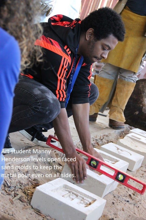 Art Student Manny Henderson levels open faced sand molds to keep the metal pour even on all sides