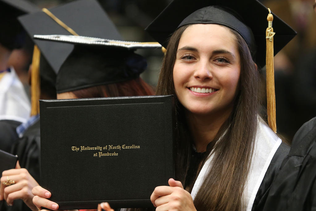 Carolina Sanchez, a member of the soccer team, proudly shows off her diploma.