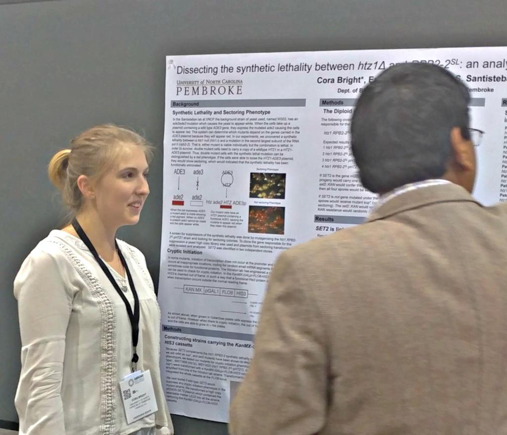 Cora Bright presenting her poster to a judge at ABRCMS.