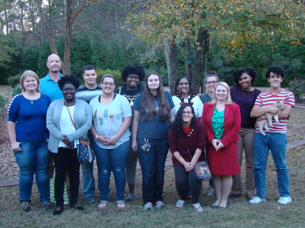 RISE Fellows and staff standing on a lawn, with trees in the background, facing the camera for a group picture.