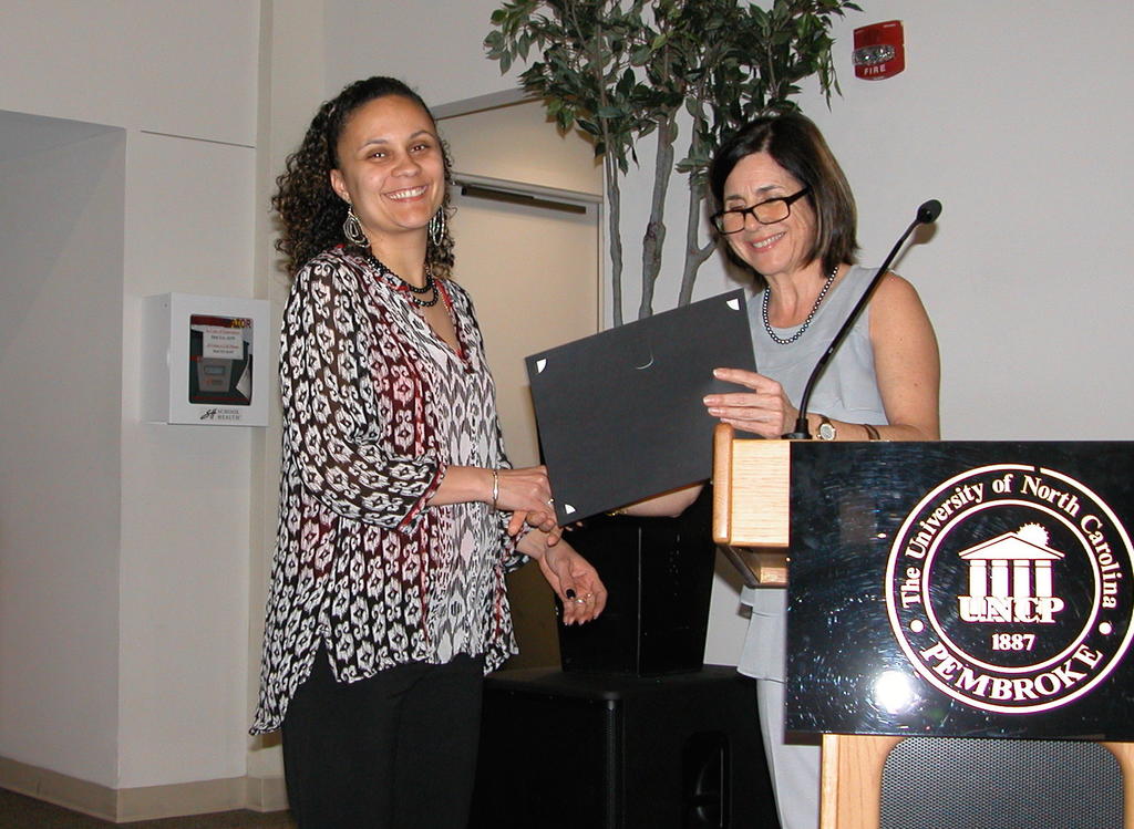 Denise Salvetti receiving the Dr. Robert Britt Memorial Scholarship from Dr. Maria Santisteban