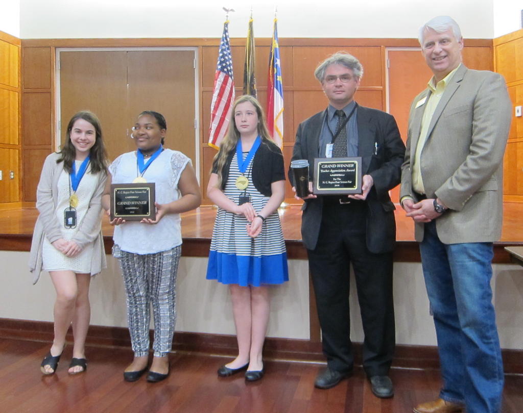 Ana Huesa, Serenity Flakes, Yasmine Benson, and their mentor Dr. Grant Pilkay are awarded overall winners at the Region IV Science Fair. Dr. Jeff Frederick, Dean of College of Arts and Sciences announced the awards