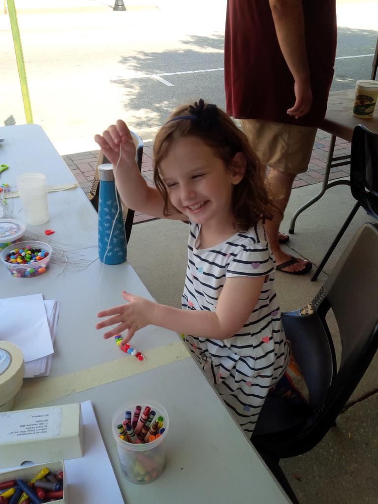 Dr. Grant's daughter Olivia enjoying making a necklace.