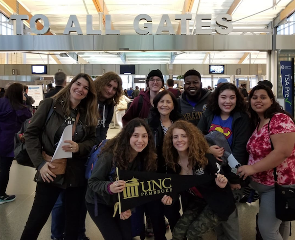 World Languages Program faculty and students pose for a picture at the airport during a spring break trip to South America. Pictured here (from left to right) are Dr. Ana Cecilia Lara, Holden Jolley, Sarah Rodriquez, Antonia Uchytil, Milagros López-Fred, Ignayara Hernandez, Zachary McDowell, Angela Dial, and Lena Paz.