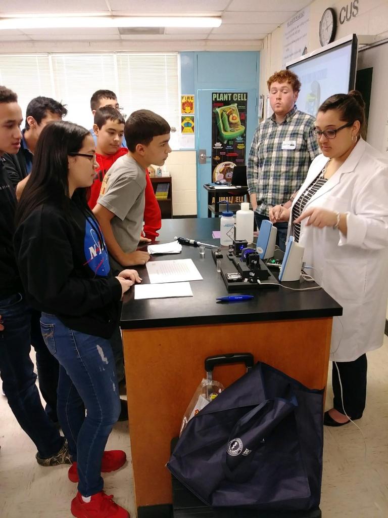 Kaitlan Smith and Josh Cade discussing an experiment with middle school students