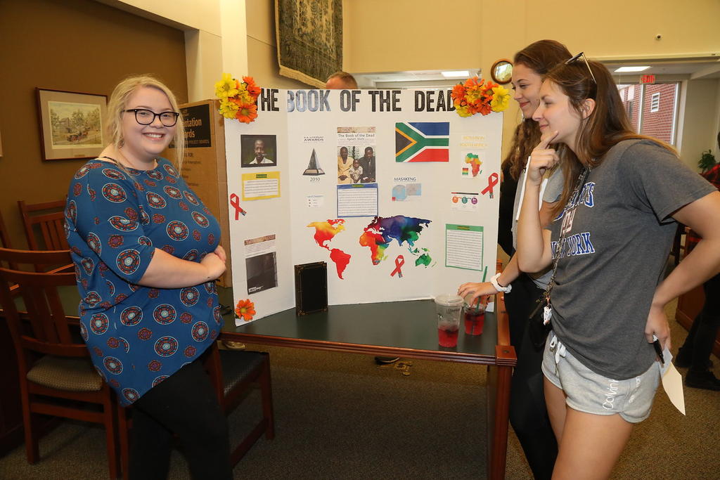 Natalie Rodgers, Shannon Skyrd and Brianna Warren show off one of the student presentations at the World Literature Book Fair