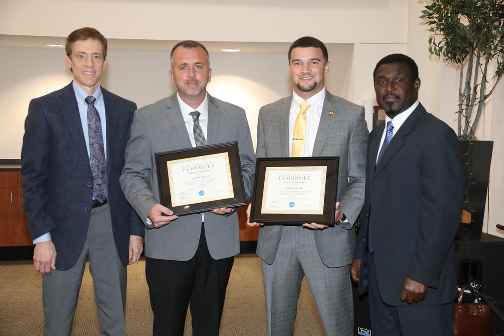 Business professors Dr. John Parnell (left) and Dr. Cliff Mensah (far right) with UNCP seniors Joey Bartch and Josh Brooks