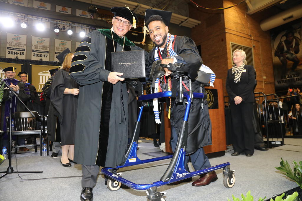 Dustin Chavis accepting his diploma from Chancellor Cummings during Graduation