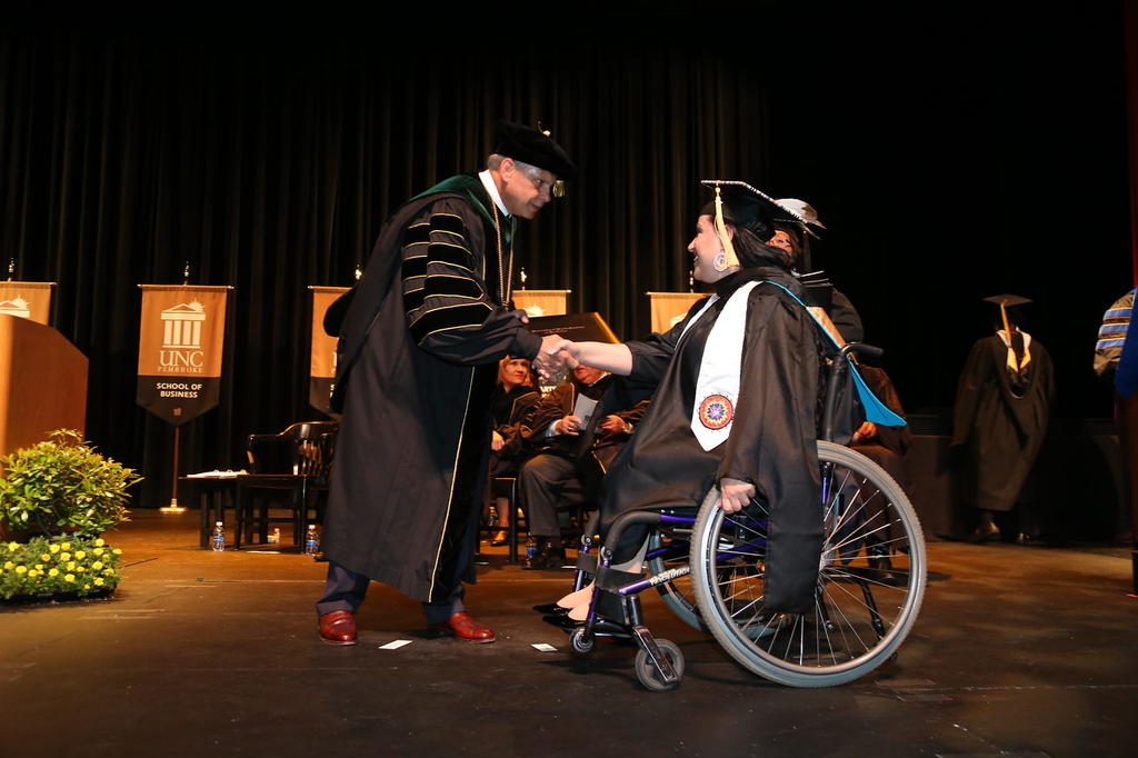 Alicia Chavis accepting her diploma from Chancellor Cummings
