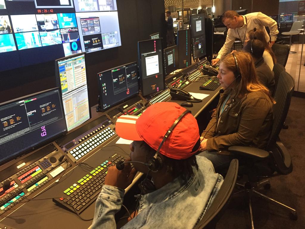 Students listen-in on the director’s cues during a live studio production at Bloomberg Television