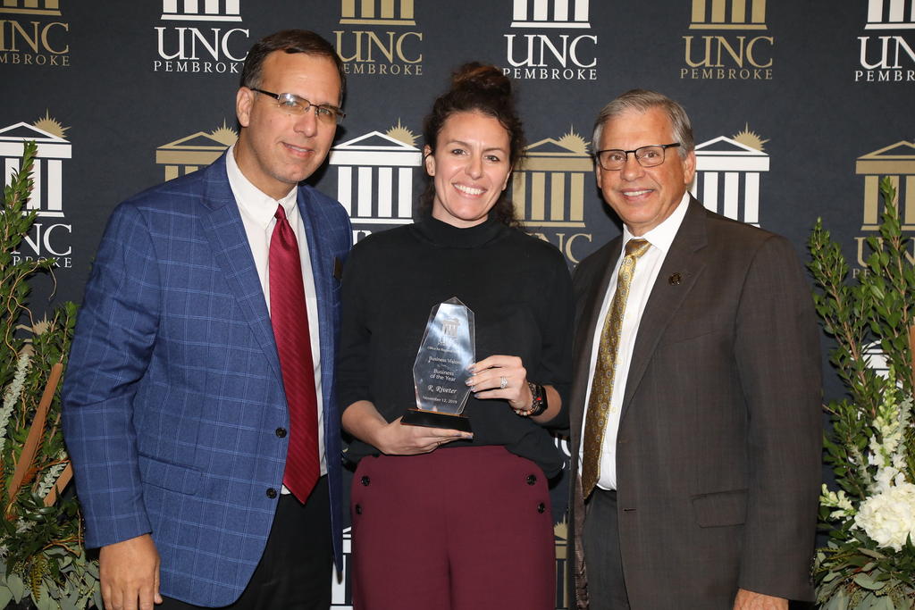 Cameron Cruse, co-founder of R. Riveter, receives the award for Business of the Year. She is shown with Paul Jolicoeur and Chancellor Cummings
