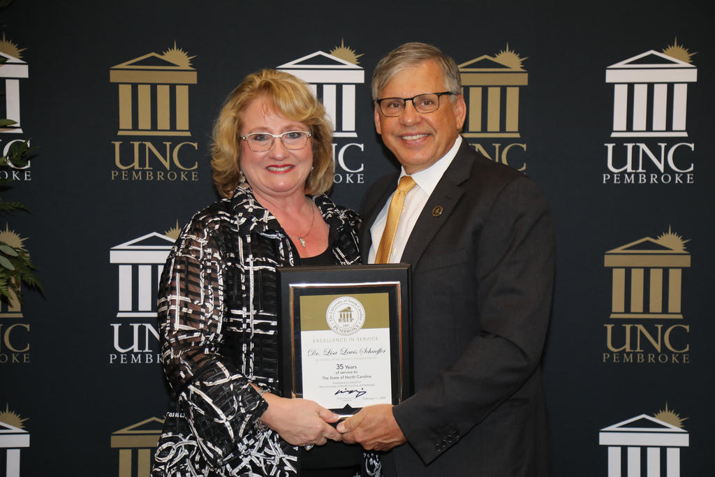 Chancellor Robin Gary Cummings presents Dr. Lisa Schaeffer, vice chancellor for Student Affairs, with a plaque recognizing 35 years of service to the university
