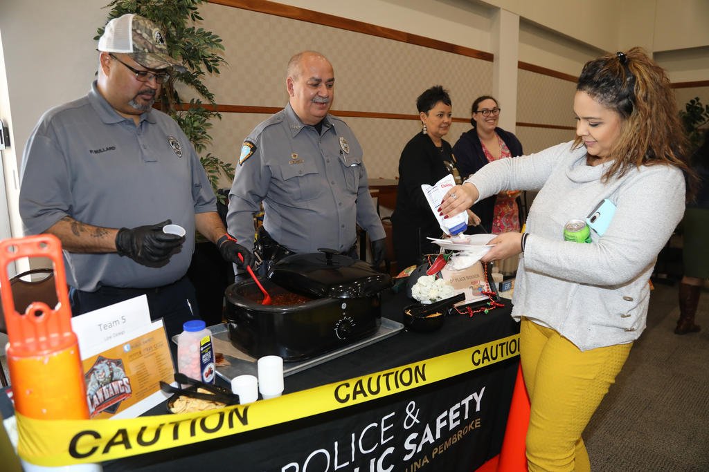 Members of the Law Dawgs team (Police & Public Safety) serve up a sample of their secret recipe at the annual Staff & Faculty Chili Cook-Off