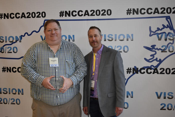 Dr. Jonathan Ricks is presented with the Devoted Service Award from NCCA President and UNCP alumnus Dr. Mark Schwarze